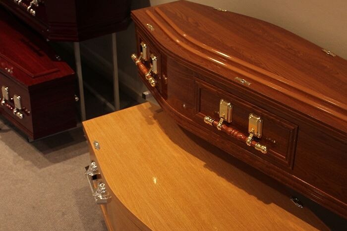 A regular-sized coffin sitting on top of a larger one.