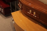 A regular-sized coffin sitting on top of a larger one.
