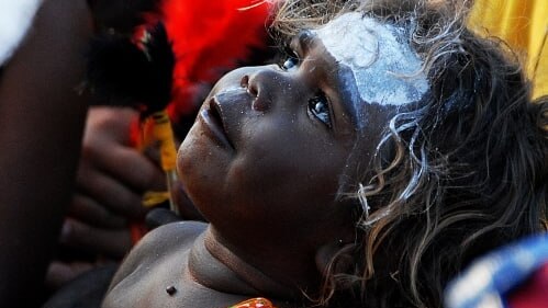An indigenous child looks up.