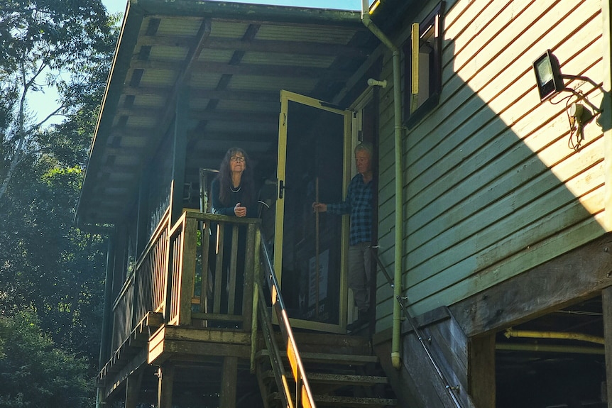 Lismore MP Janelle Saffin and her husband Jim sanding on their verandah, where Jim clung onto for hours during the floods.