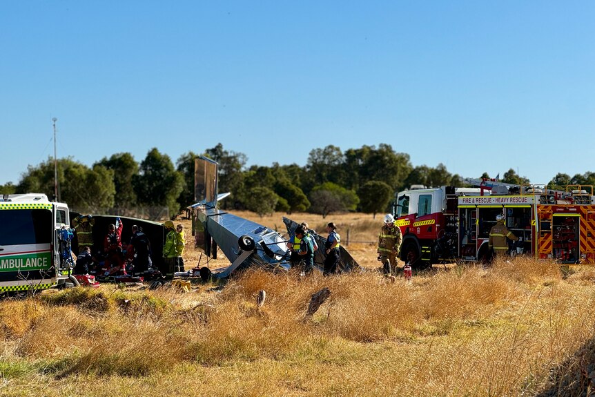 The scene of the plane crash near bunbury, police officers and firefighters inspect the scene and paramedics treat the pilot.
