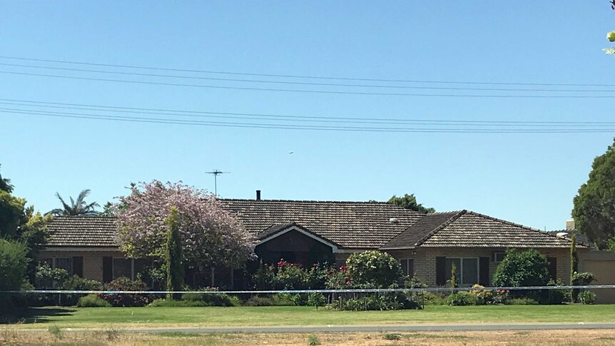 A house with police tape in front of it.