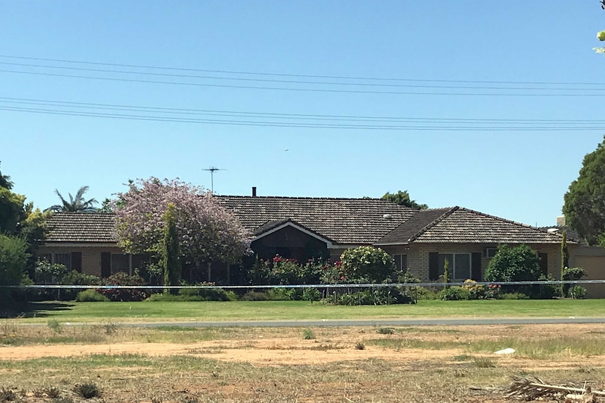 A house with police tape in front of it.