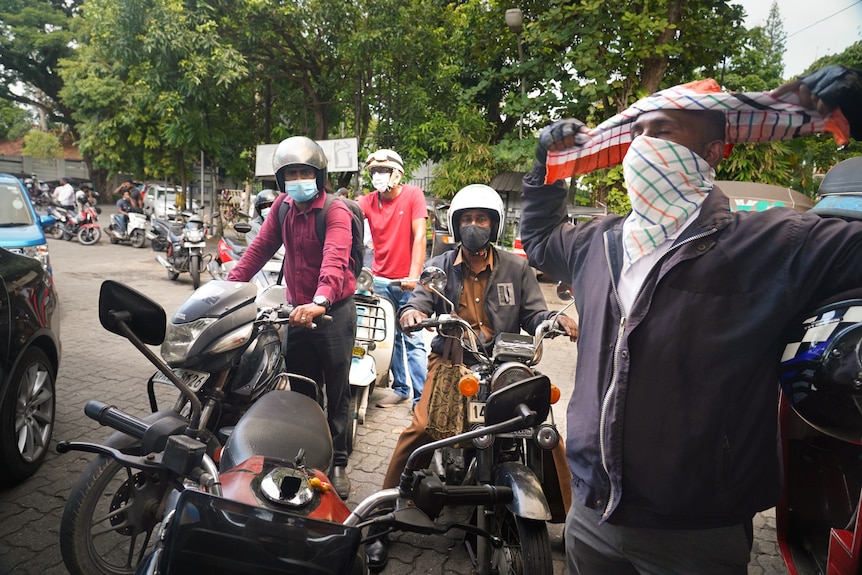 A long snaking queue of men on motorbikes 