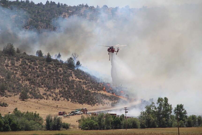 A helicopter makes a drop on the Klamathon Fire along Copco Road in Hornbrook. There is a lot of smoke.