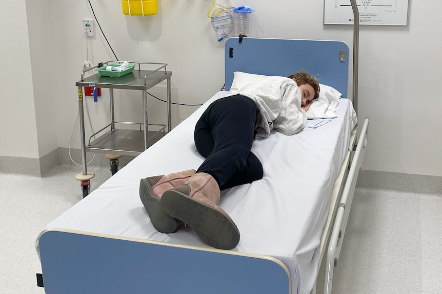 a woman lies in a hospital bed