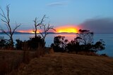 Fires burn at Forcett, just east of Hobart, as seen from across Storm Bay.