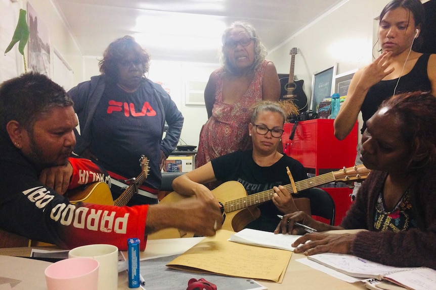 people sitting with guitars