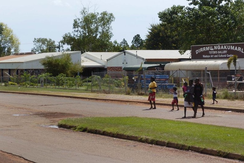 Women and children cross the main street in the NT Aboriginal town of Wadeye
