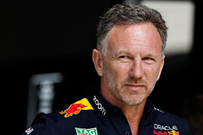 Christian Horner, a caucasian male with stubble, on an F1 pitwall staring to the side.
