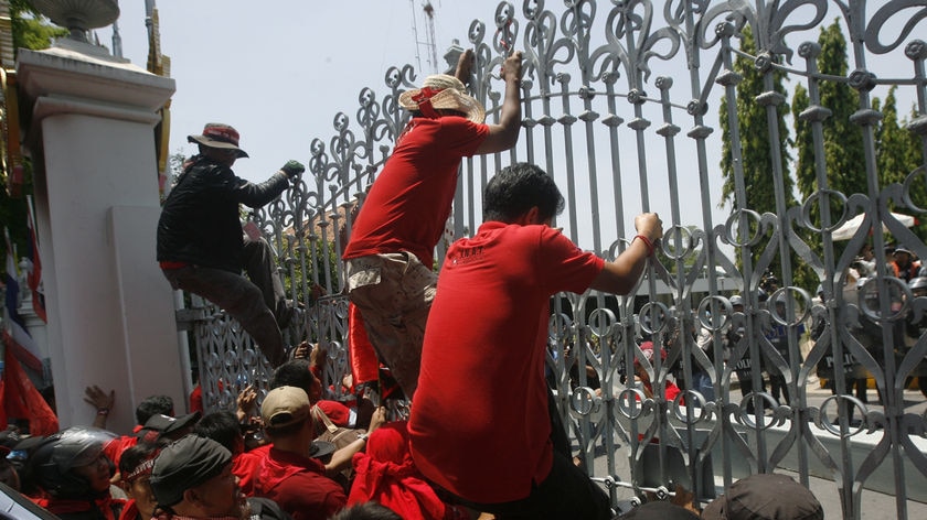 Red shirt protesters scale the gates of Thailand's parliament