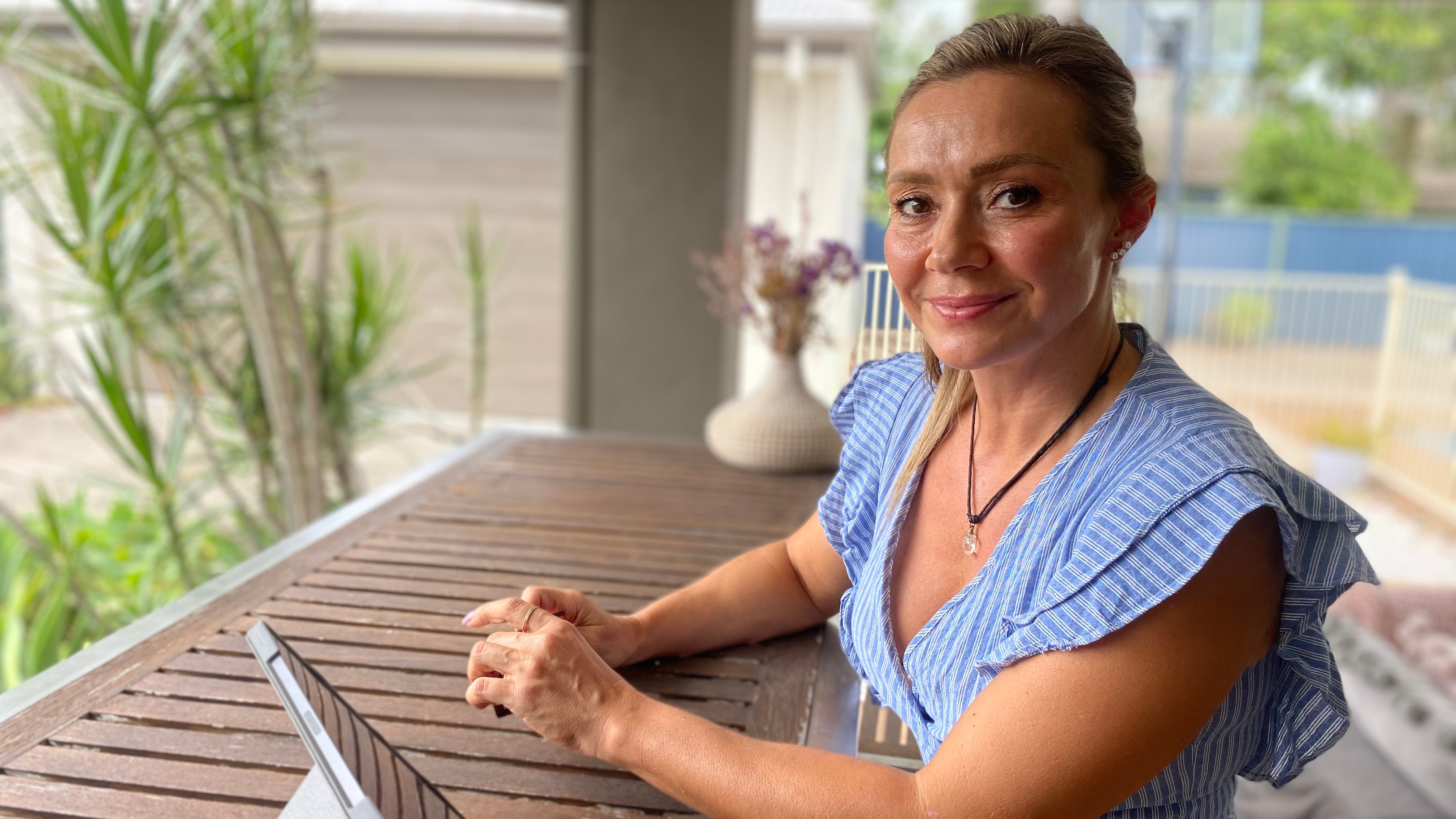 A woman sitting at a desk outdoors.