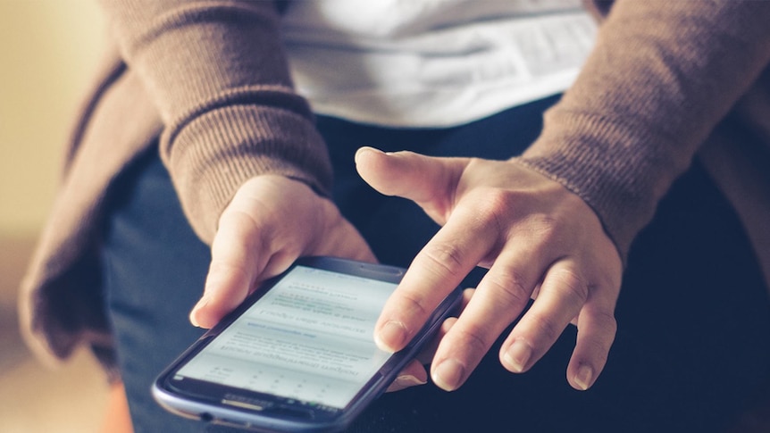 A woman uses a smartphone.