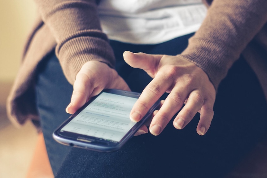 A woman uses a smartphone.