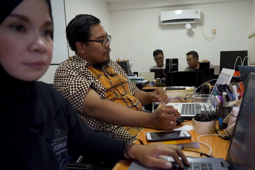 Four people working on their laptops in an office in Jakarta