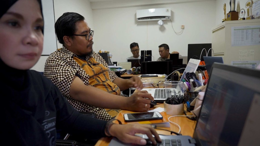 Four people working on their laptops in an office in Jakarta