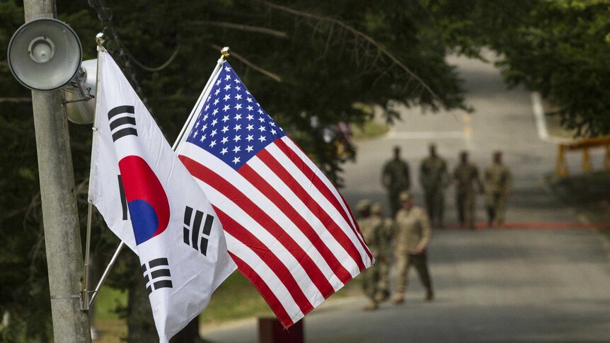 South Korea, US flag, soldiers in background