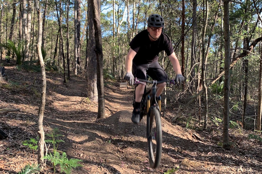 A man riding a mountain bike on a forest trail.