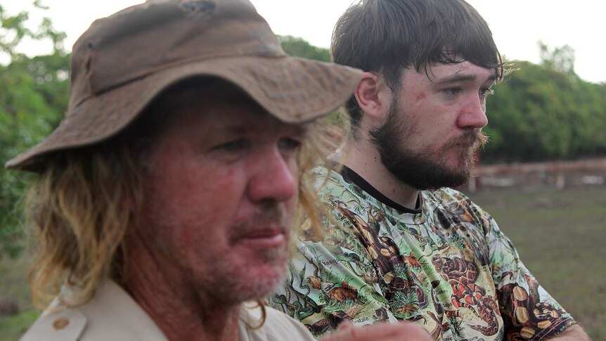 A photo of Phillip and Trevor Sullivan looking on at a pet crocodile.