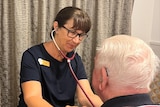 a nurse assessing an old man