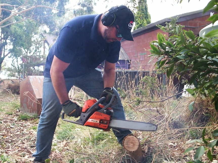 Man with chainsaw in backyard