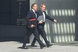 LNP Member for Moggill Bruce Flegg (right) and his lawyer enter the Brisbane court complex.