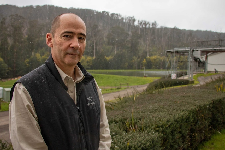 A man on his farm at Kinglake with rain falling around him.