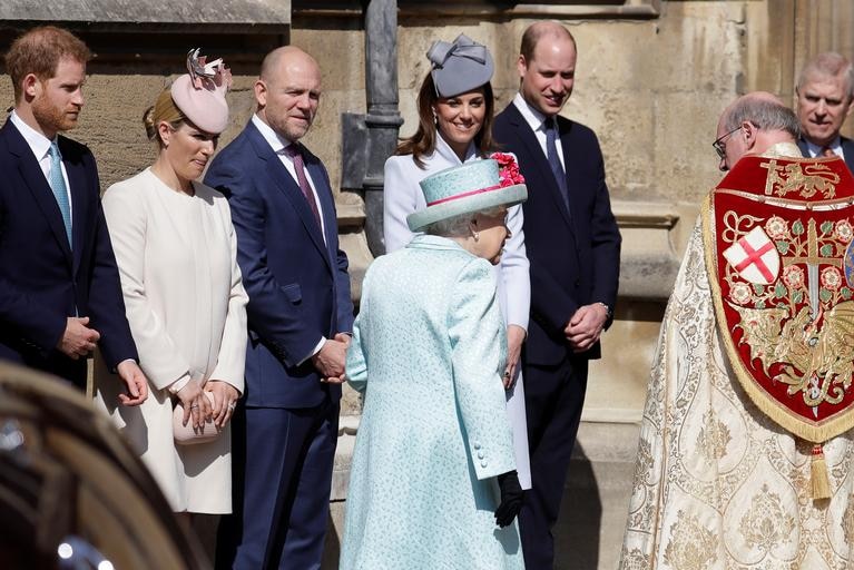 The Queen walks in with the priest, past Harry, Zara, Mike, Kate and William.