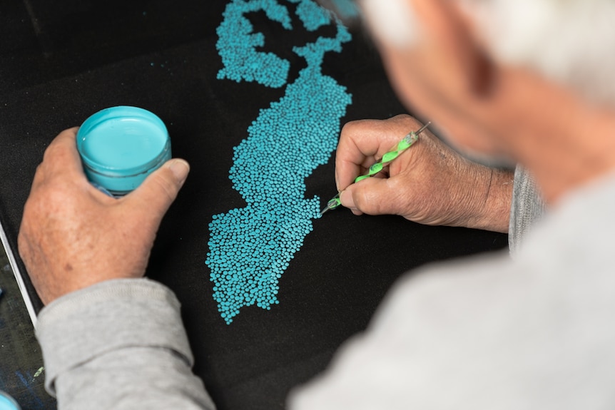 Close up of Lloyd painting a constellation
