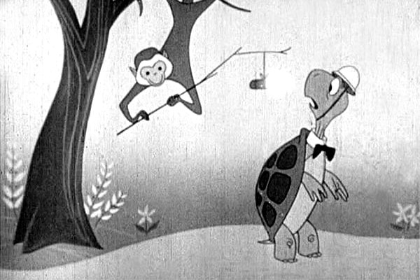 A black and white image of a turtule with a monkey holding a dynamite stick from a tree.