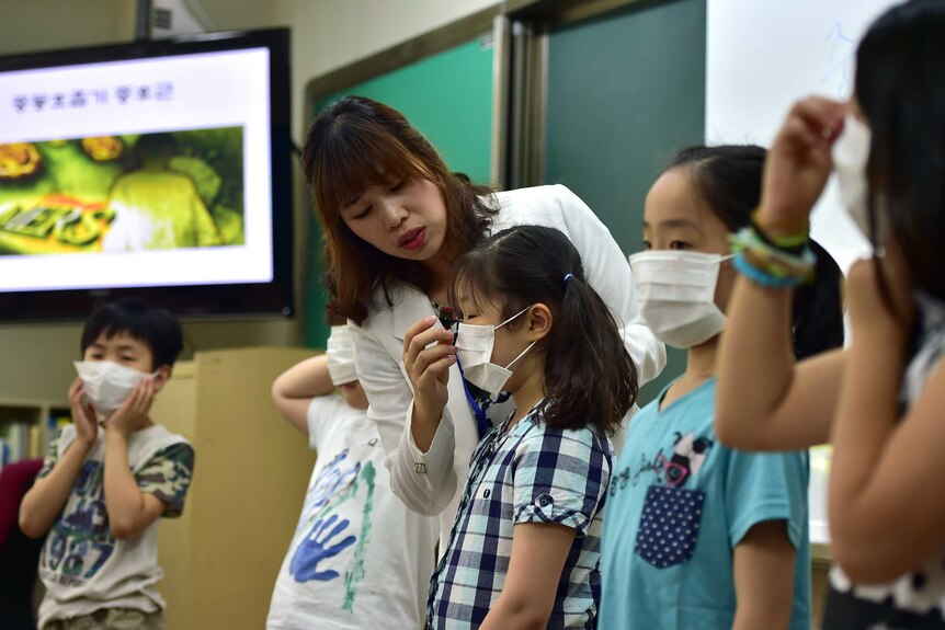 School children in South Korea are shown how to wear face masks to prevent the spread of the MERS virus