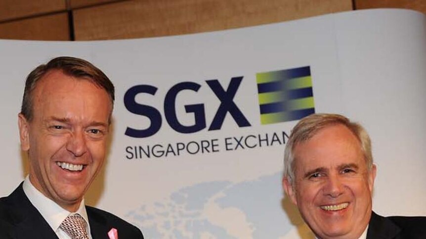 SGX and ASX CEOs (LtoR) Magnus Bocker and Robert Elstone shake hands on the merger between the two exchanges.