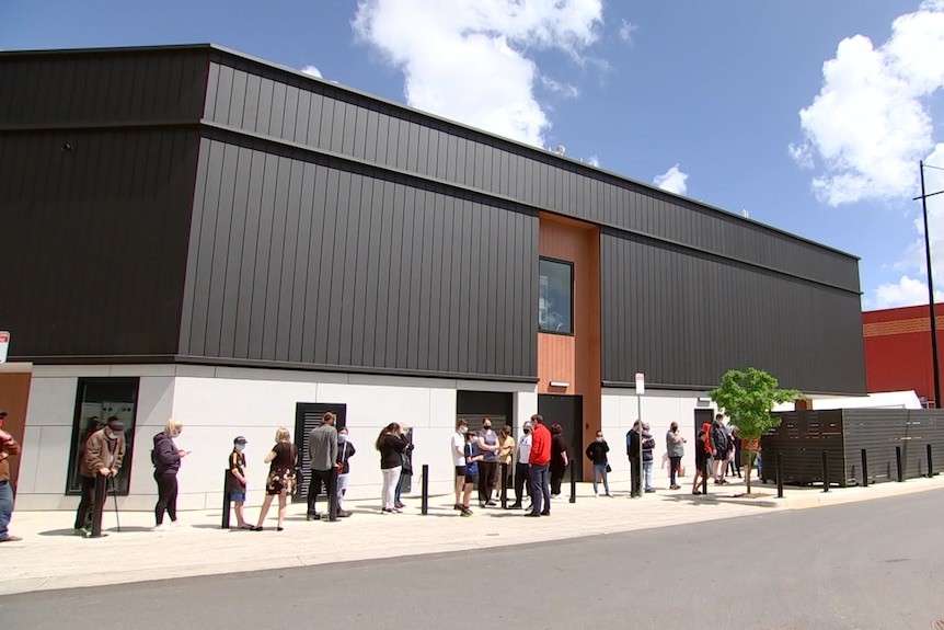 People lining up outside a big box building