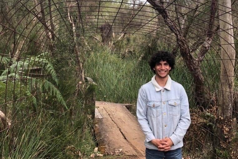 A man standing outside smiles at the camera.