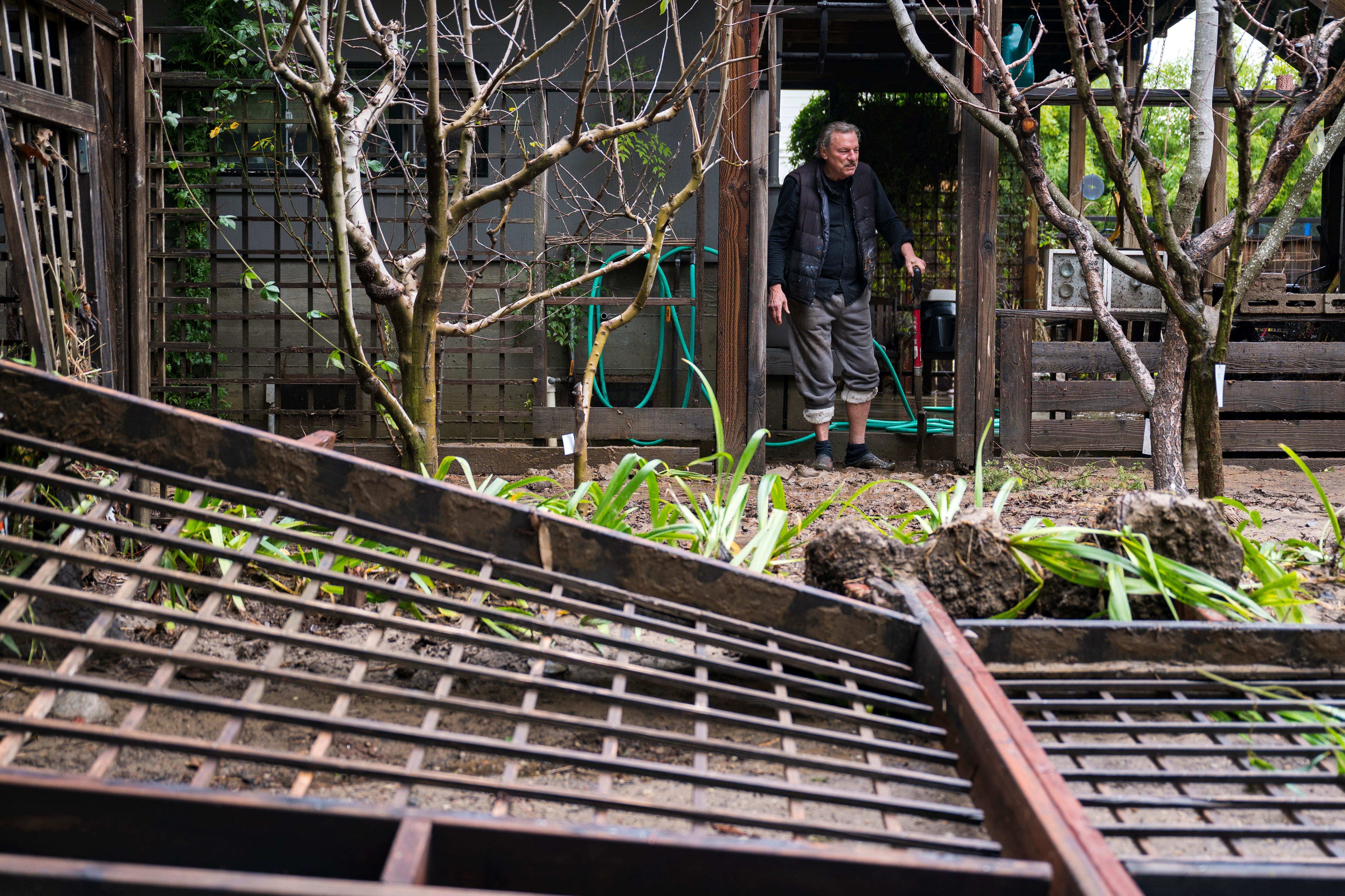 A man in a door way with fallen gates in front of it