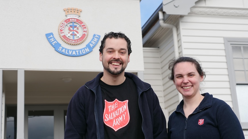 A young couple stand in front of the salvation army building