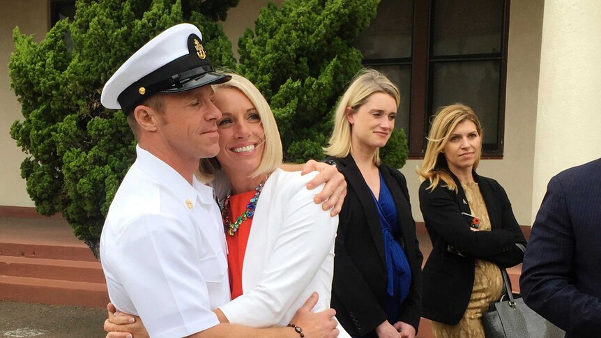 Edward Gallagher in Naval uniform (left) hugs his wife after leaving a courtroom.