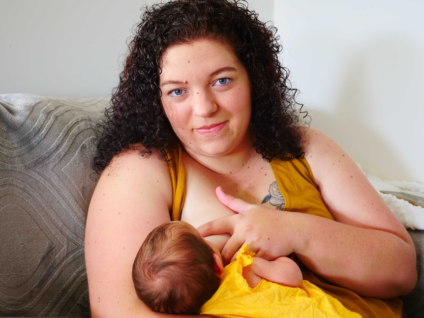 A woman holds her sleeping baby.