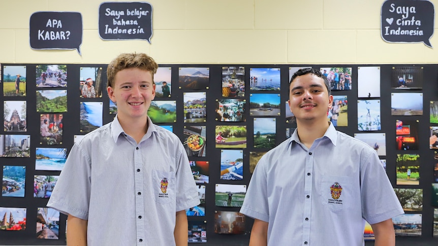 Two teenage boys look at the camera smiling