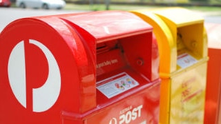 Australia Post mail boxes stand by the side of the road.