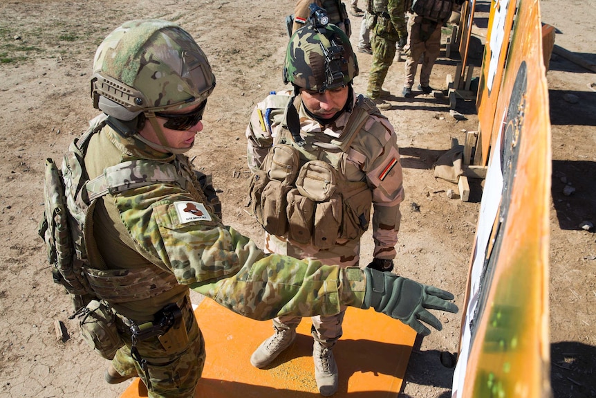 An Australian soldier trains an Iraqi soldier