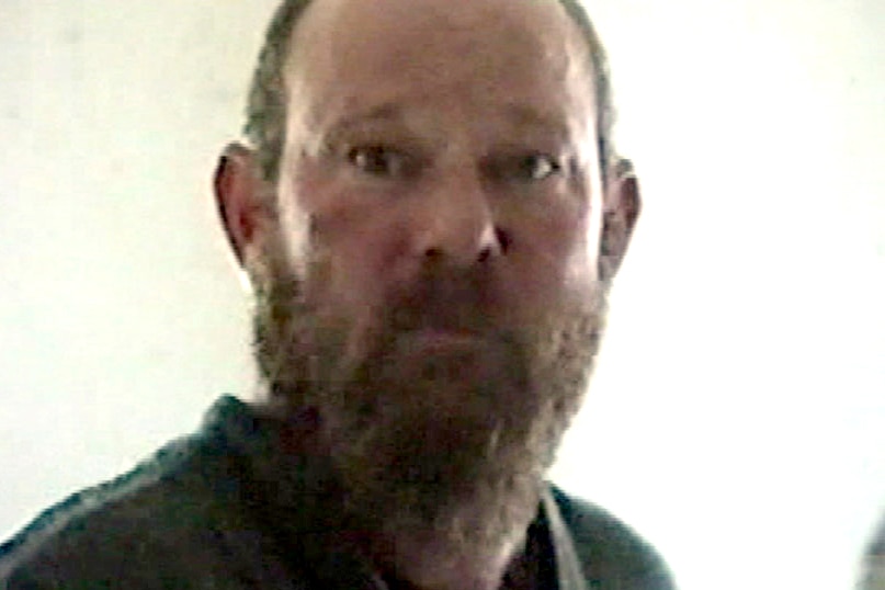 Une photo serrée de la tête et des épaules de Francis Wark tirée d'une vidéo de la police tournée lors d'une perquisition à sa maison en 1999.
