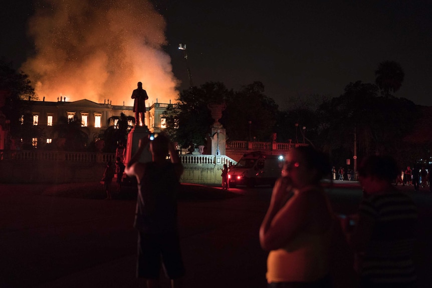 People watch as flames engulf the museum.