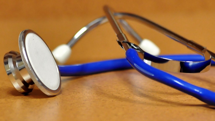 A doctor's stethoscope sits on a table.