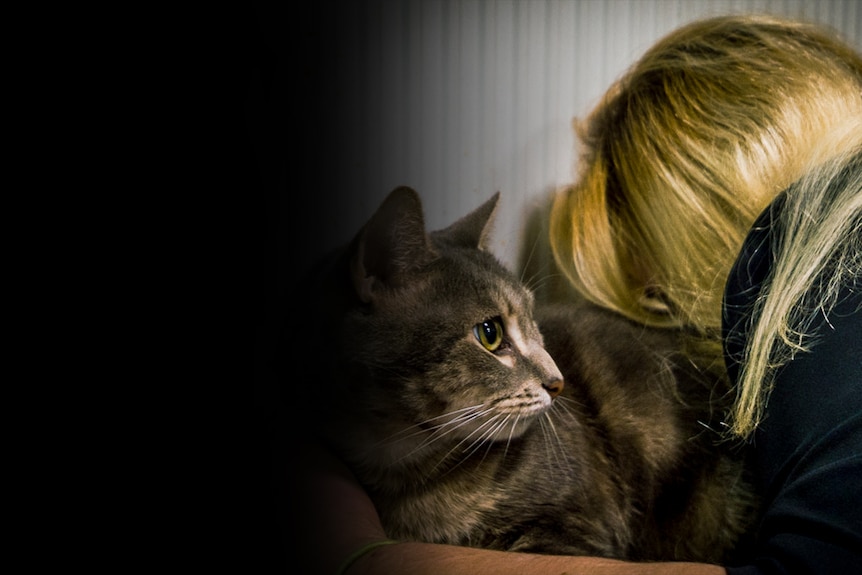 A woman hugging a cat.