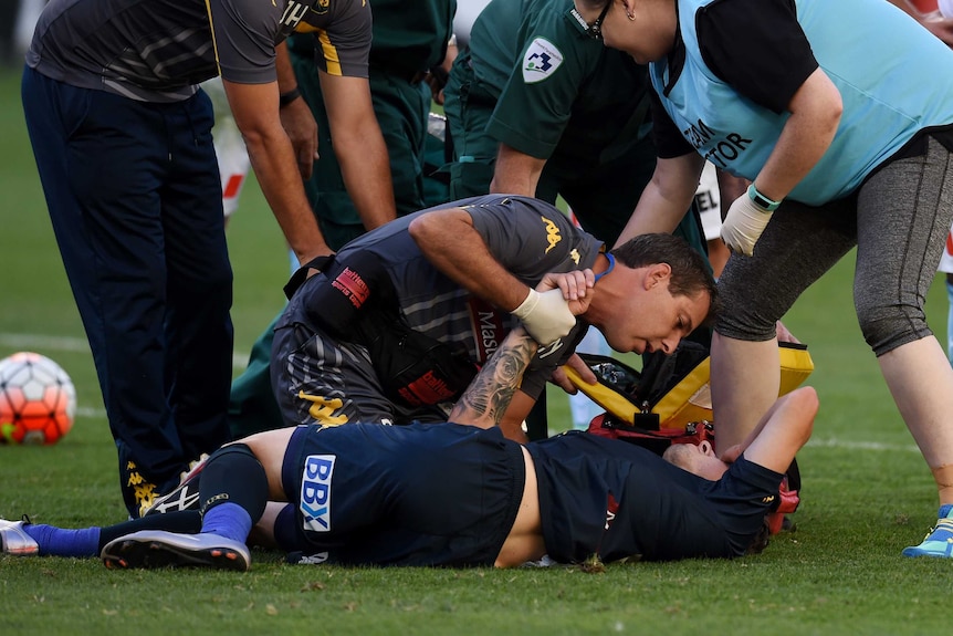 Storm Roux is seen to by doctors after injuring his ankle against Melbourne City