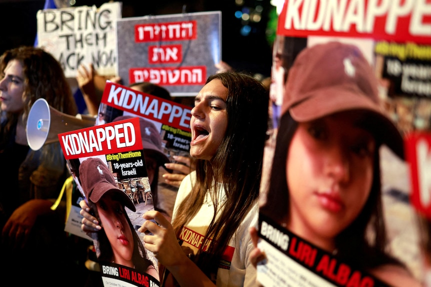 Young people protest, holding signs with "kidnapped" written on them