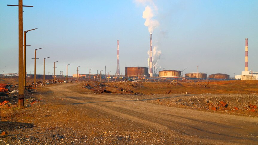 Oil storage tanks outside Norilsk can be seen in the distance in this photo. The earth appears red in some parts.