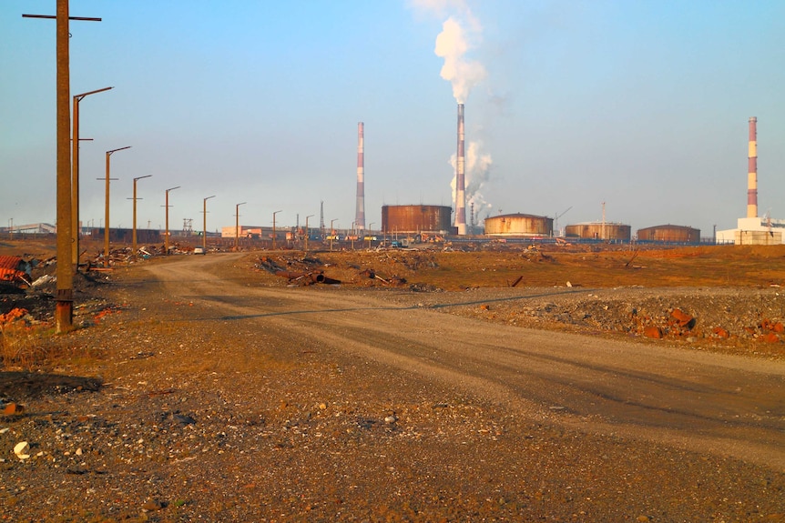 Oil storage tanks outside Norilsk can be seen in the distance in this photo. The earth appears red in some parts.