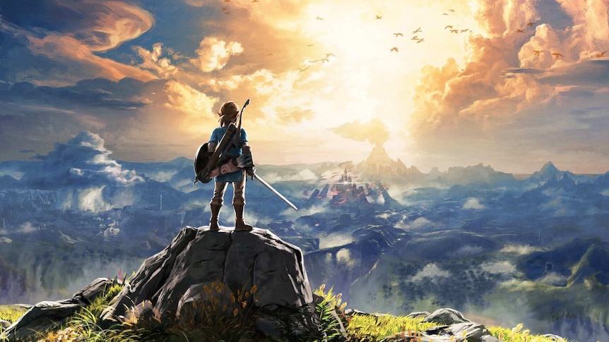 A young blonde hero dressed for war looks out over a foggy mountainous landscape.